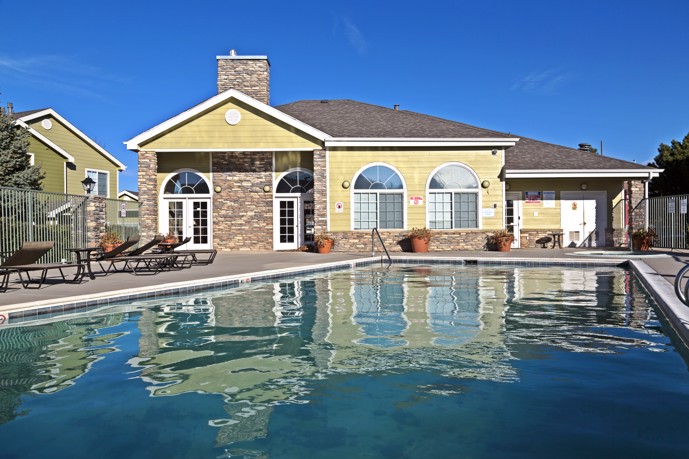 Outdoor pool surrounded by lounge chairs and umbrellas at Peakview at T-Bone Ranch.